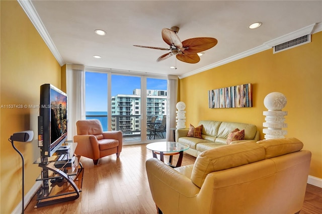 living room featuring wood-type flooring, ornamental molding, and ceiling fan