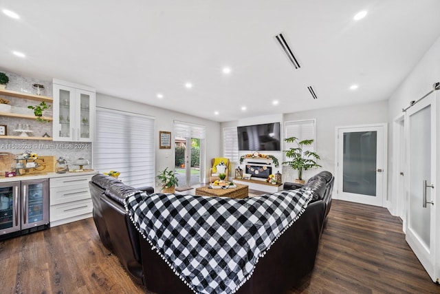 living room featuring dark hardwood / wood-style floors, beverage cooler, and a barn door