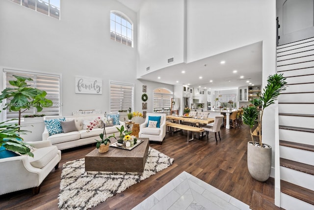 living room with dark hardwood / wood-style flooring and a high ceiling