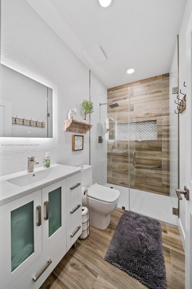 bathroom with an enclosed shower, toilet, and vanity