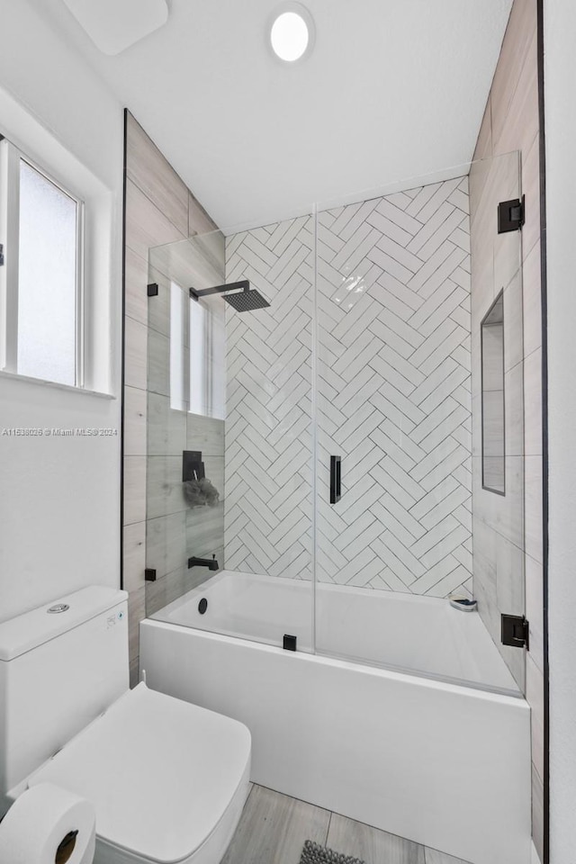 bathroom with toilet and enclosed tub / shower combo