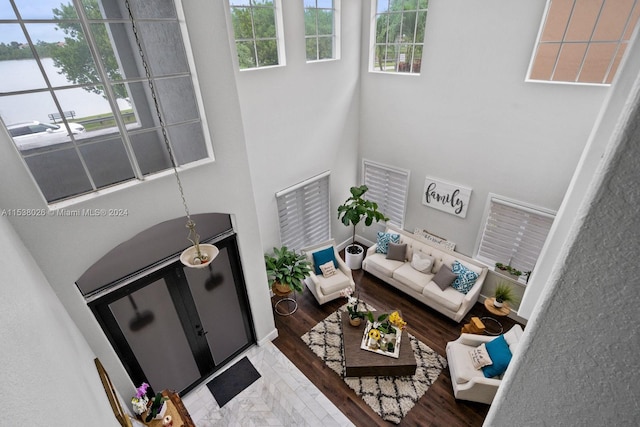 living room with dark hardwood / wood-style floors and a towering ceiling