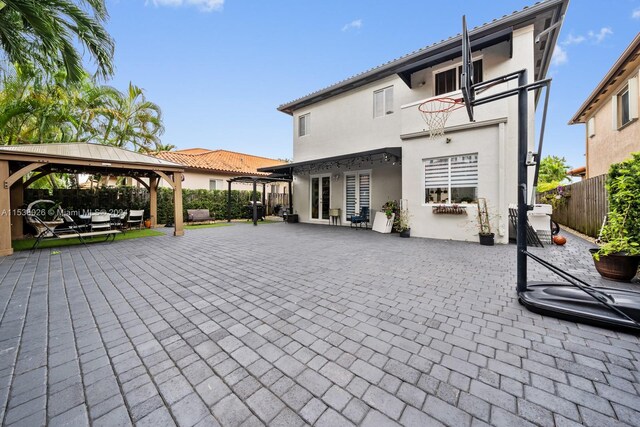 rear view of property featuring a gazebo and a patio