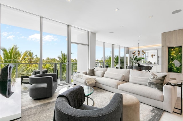 living room featuring light hardwood / wood-style flooring, expansive windows, a notable chandelier, and a wealth of natural light