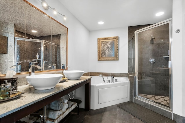 bathroom featuring double sink, large vanity, tile flooring, and plus walk in shower