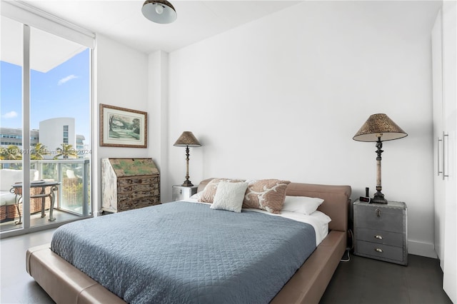 bedroom featuring a wall of windows and dark tile floors