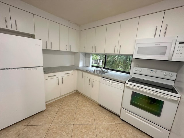 kitchen featuring white appliances, white cabinets, sink, and light tile floors