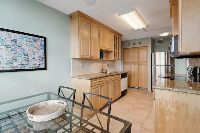 kitchen featuring sink, stainless steel appliances, light tile patterned floors, and light stone countertops