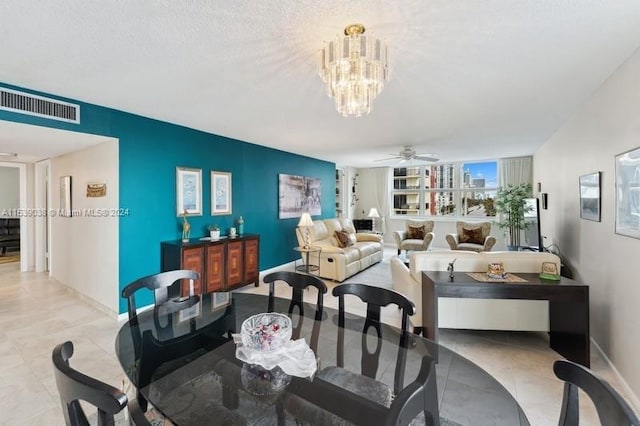 dining area featuring a textured ceiling and ceiling fan with notable chandelier