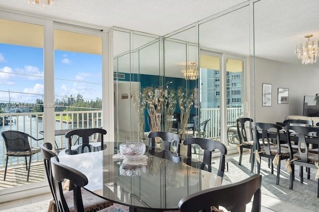 tiled dining room featuring floor to ceiling windows, a chandelier, a water view, and a textured ceiling