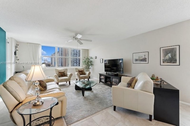 tiled living room featuring ceiling fan and a textured ceiling