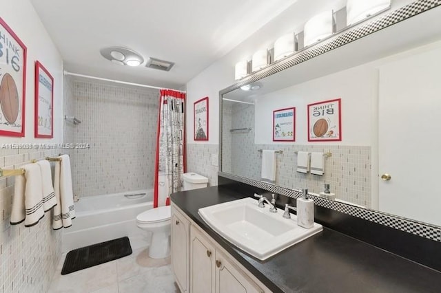 full bathroom with toilet, shower / bath combination with curtain, tile walls, tile patterned floors, and vanity