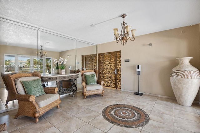 sitting room with a textured ceiling, french doors, a chandelier, and light tile patterned floors