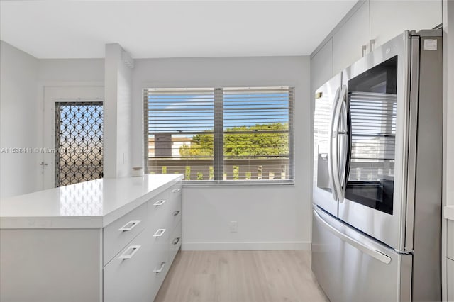 kitchen featuring light hardwood / wood-style flooring, kitchen peninsula, and stainless steel refrigerator with ice dispenser