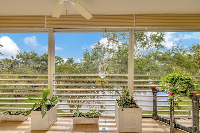 unfurnished sunroom featuring ceiling fan and a wealth of natural light