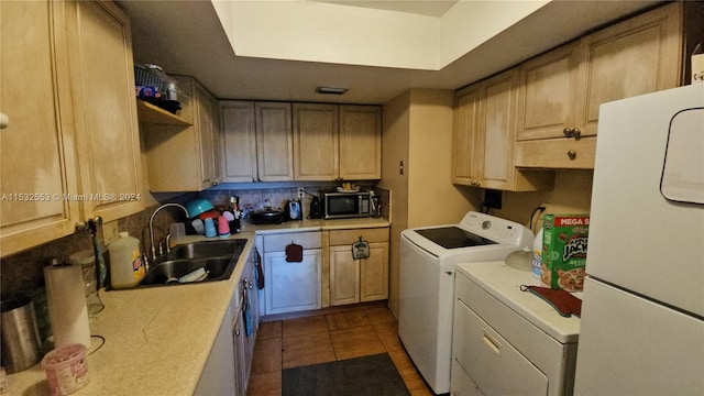 kitchen featuring white refrigerator, washer and dryer, backsplash, sink, and tile floors