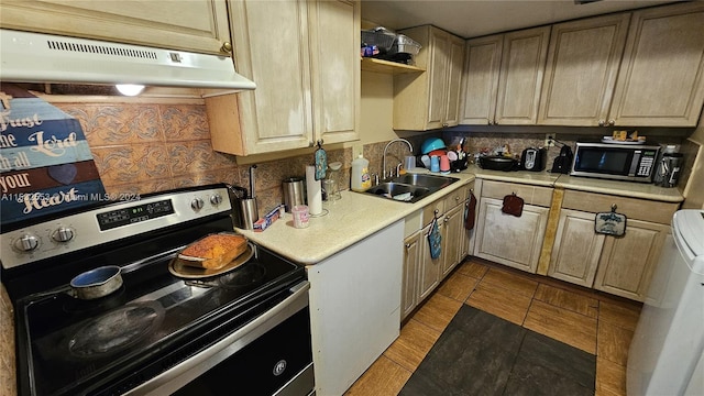 kitchen featuring appliances with stainless steel finishes, sink, tasteful backsplash, and light tile flooring