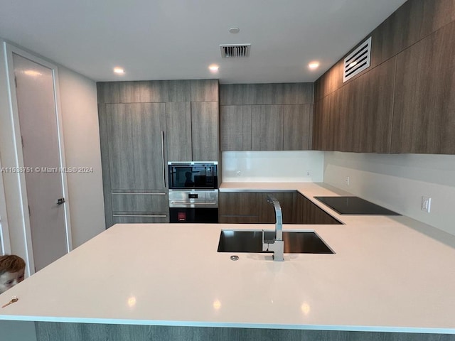 kitchen featuring gray cabinetry, black appliances, and sink