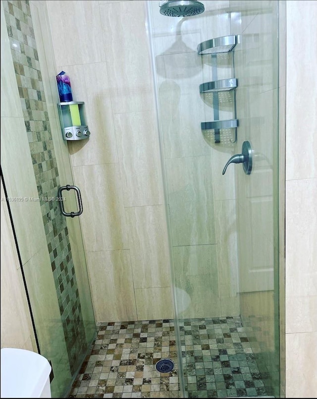 bathroom with toilet and a shower with shower door