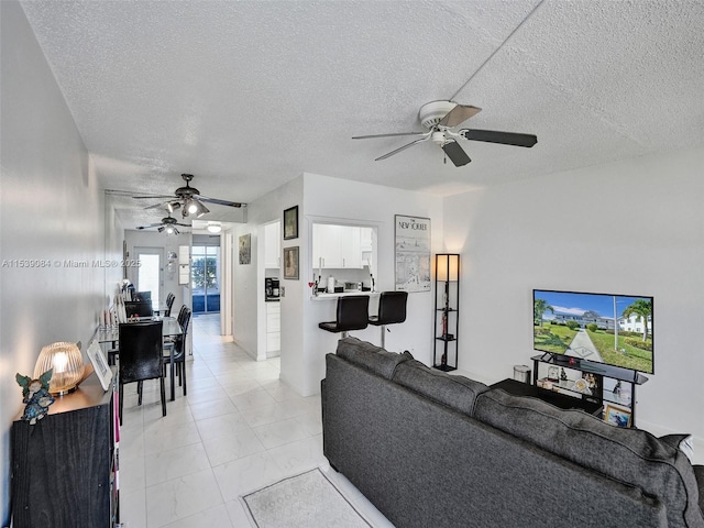 living room featuring ceiling fan and a textured ceiling