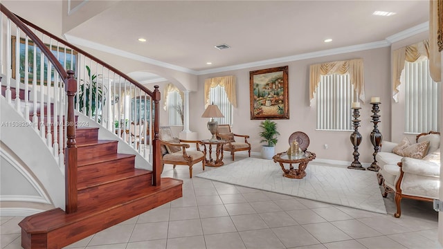 tiled foyer featuring crown molding, ornate columns, and a wealth of natural light