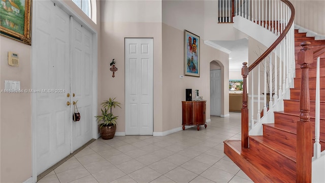 tiled entrance foyer with a towering ceiling