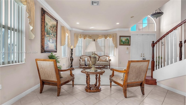 sitting room with light tile floors, crown molding, and a wealth of natural light