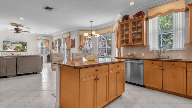 kitchen featuring stainless steel dishwasher, ceiling fan with notable chandelier, backsplash, hanging light fixtures, and sink