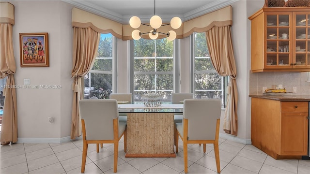 dining room featuring light tile floors, plenty of natural light, a chandelier, and ornamental molding