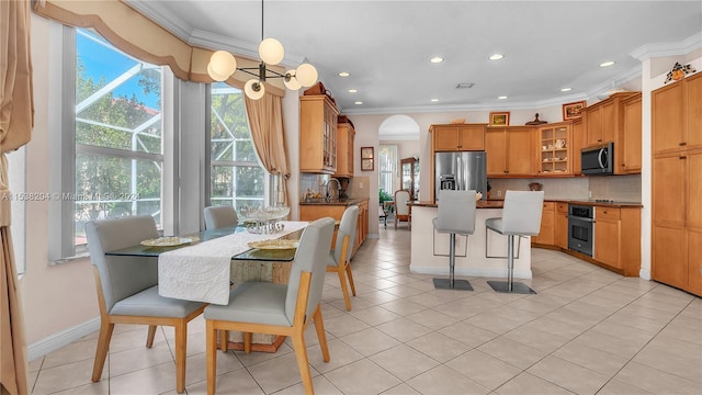 tiled dining area with a chandelier and ornamental molding