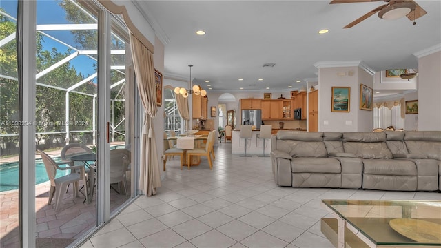 unfurnished living room featuring plenty of natural light, crown molding, light tile floors, and ceiling fan with notable chandelier