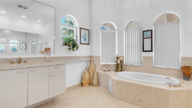 bathroom with tiled tub, tile floors, vanity, and a towering ceiling