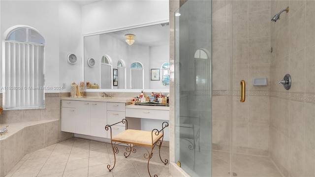 bathroom with shower with separate bathtub, tile floors, and vanity