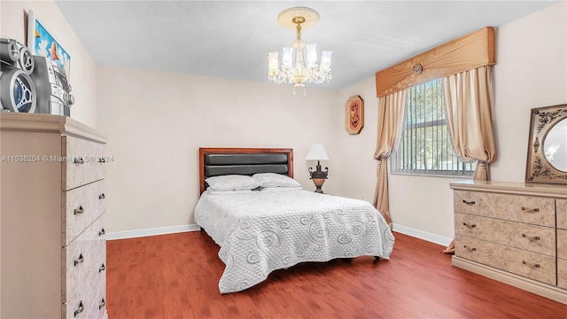 bedroom featuring dark hardwood / wood-style floors and a notable chandelier