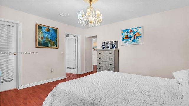 bedroom with dark wood-type flooring and a chandelier