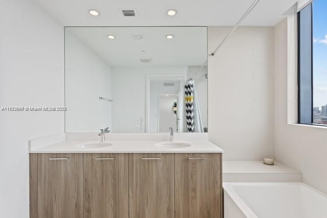 bathroom with vanity and shower with separate bathtub