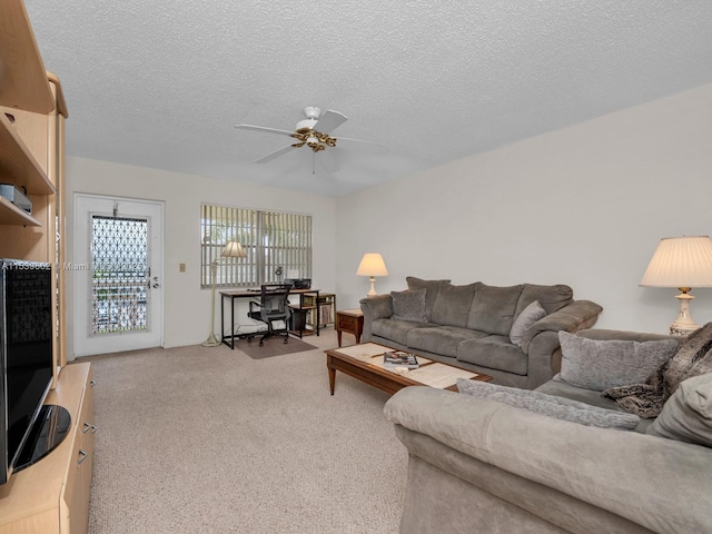 living room featuring light carpet, ceiling fan, and a textured ceiling