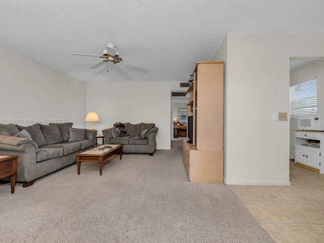 carpeted living room featuring ceiling fan and a textured ceiling