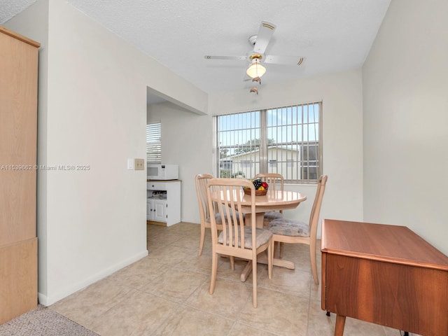 dining room featuring ceiling fan, a textured ceiling, and light tile patterned floors