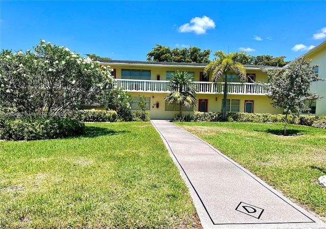 view of front of property with a balcony and a front yard