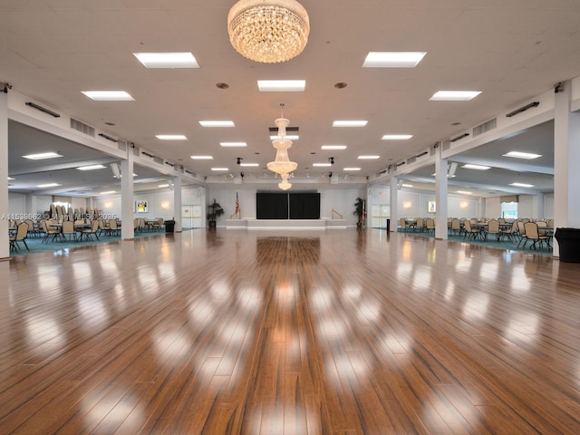 exercise area featuring hardwood / wood-style flooring and a notable chandelier