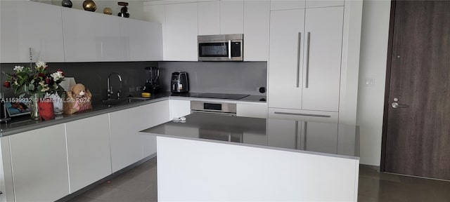 kitchen with white cabinetry, backsplash, sink, a center island, and black electric stovetop