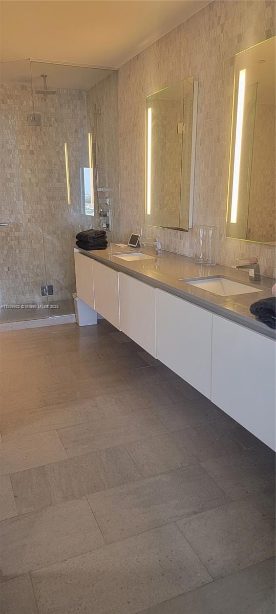 bathroom featuring backsplash, tile flooring, dual sinks, and oversized vanity