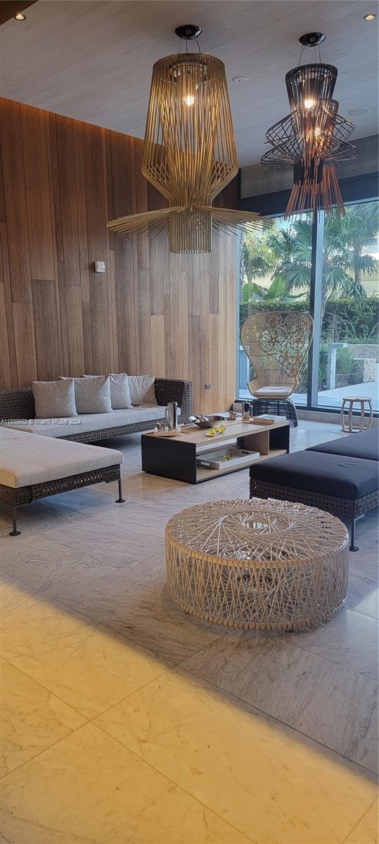 living room with an inviting chandelier and wooden walls