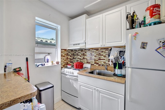 kitchen with white appliances, white cabinetry, backsplash, light tile floors, and sink