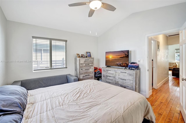 bedroom with vaulted ceiling, ceiling fan, and light wood-type flooring