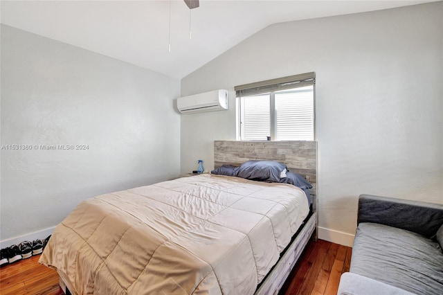 bedroom featuring a wall unit AC, dark hardwood / wood-style flooring, ceiling fan, and vaulted ceiling