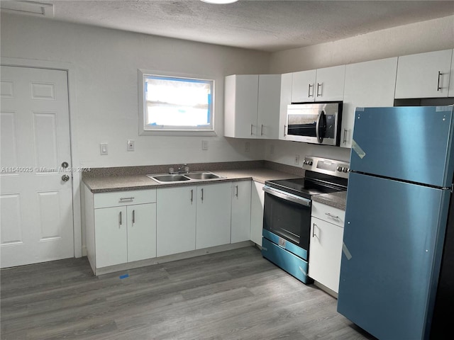 kitchen featuring white cabinets, light hardwood / wood-style floors, stainless steel appliances, and sink