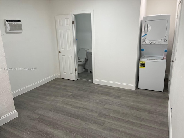 clothes washing area with a wall mounted air conditioner, stacked washer / dryer, and dark hardwood / wood-style floors