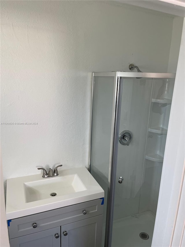 bathroom with vanity and a shower with door